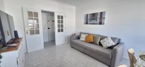 a living room with a gray couch and a table at Maré Viva in Quarteira
