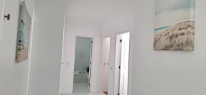 a hallway with white walls and a painting on the wall at Maré Viva in Quarteira +13 photos