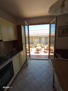 a kitchen with a door open to a patio at Alba Blu Sampieri in Sampieri
