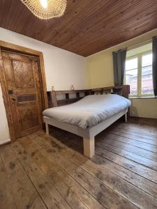 a bedroom with a bed and a wooden floor at Comme à La Maison in Cayres