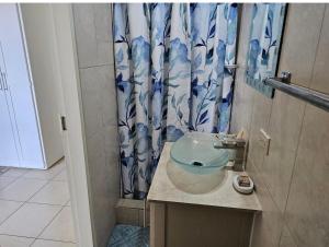 a bathroom with a sink and a shower curtain at Riseland Breeze Collection in Carnbee Village +44 photos