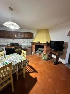 a kitchen with a dining table and a fireplace at B&B Pizziconi Relax in Podere Modello