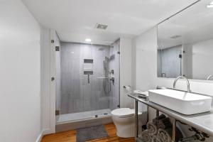 a bathroom with a shower and a sink and a toilet at Industrial Modern Loft in Downtown Lafayette in Lafayette +22 photos