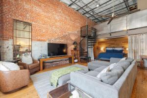 a living room with a brick wall at Industrial Modern Loft in Downtown Lafayette in Lafayette