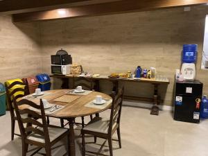 a table and chairs in a room with a kitchen at Savannah Pousada in São Paulo