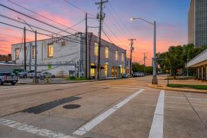 an empty street in a city with a sunset at Industrial Modern Loft in Downtown Lafayette in Lafayette