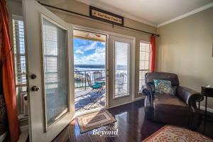 a living room with a chair and a balcony at Sunset & Lake View on Island Retreat in Lago Vista