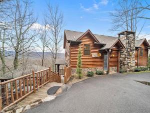 a log cabin with a wooden fence and a driveway at Eden's View in Gatlinburg