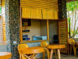 a restaurant with wooden tables and chairs and a counter at Breezy Lodge in Moshi