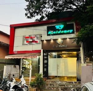 a store with a motorcycle parked in front of it at Hotel KF Residency in Mumbai