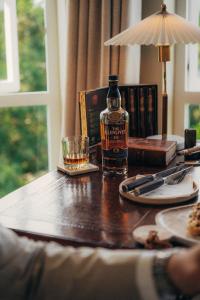 a bottle of whiskey and a glass on a table at Redlands Hotel in Pietermaritzburg +104 photos