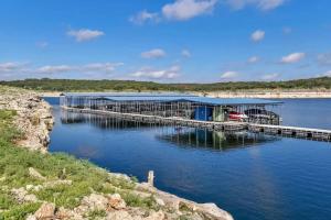 a dock with a building on a body of water at Pets Stay Free, Breezy, Stylish Island Elegance in Lago Vista