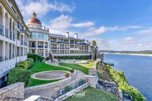 an exterior view of a large building next to the water at Pets Stay Free, Breezy, Stylish Island Elegance in Lago Vista +77 photos