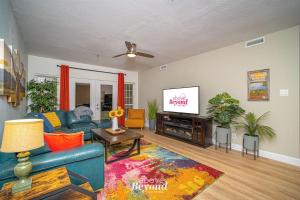 a living room with a blue couch and a tv at Color Pop by the Pool in Lago Vista