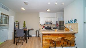 a kitchen with white cabinets and a island with bar stools at Color Pop by the Pool in Lago Vista