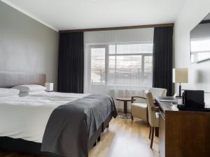 a bedroom with a bed and a desk with a computer at Hotel Kea by Keahotels in Akureyri
