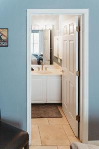 a white bathroom with a sink and a mirror at Stylish Island Villa on Lake Travis in Lago Vista +68 photos