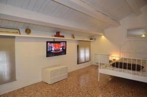 a bedroom with a bed and a tv on the wall at La Spiga apartment near Venice in Noale