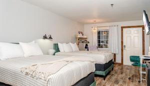 a bedroom with two beds and a table and a window at Glam Jam! - Newly Remodeled Stay in Style! Pets Stay Free in Branson