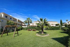 a yard with a playground with a swing at Nuevo Torrox Deluxe Beach & Piscina in Torrox