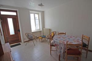a dining room with a table and chairs and a door at Tata thérèse in Ambazac