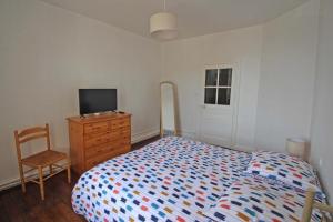 a bedroom with a bed and a dresser and a television at Tata thérèse in Ambazac