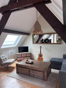 a living room with a coffee table and a guitar at Le face mer in Le Portel
