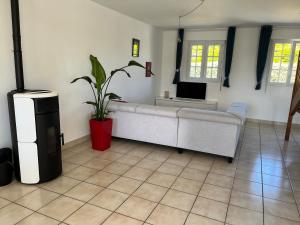 a living room with a couch and a tv at Maison de plage in Guissény