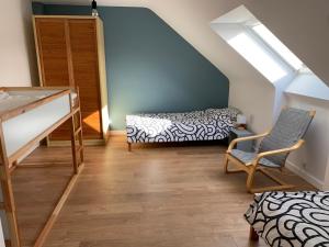 a attic room with a bunk bed and a staircase at Maison de plage in Guissény