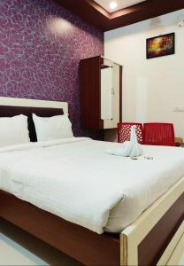 a bedroom with a large bed and a purple wall at GURU RESIDENCY yercaud in Yercaud