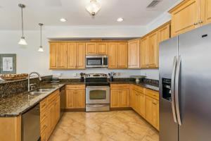 a kitchen with wooden cabinets and stainless steel appliances at 445 Fort Pickens Rd in Pensacola Beach +27 photos