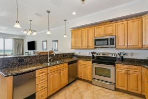 a kitchen with wooden cabinets and stainless steel appliances at 445 Fort Pickens Rd in Pensacola Beach