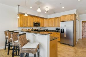 a kitchen with wooden cabinets and a stainless steel refrigerator at 445 Fort Pickens Rd in Pensacola Beach