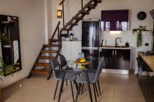 a kitchen with a table and chairs and a staircase at Live Puertito Neptune Beach in Puertito de Güímar