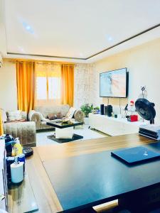 a living room with a couch and a tv at Qlbs sweet room in Abidjan