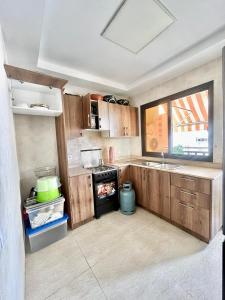 a kitchen with wooden cabinets and a sink and an oven at Qlbs sweet room in Abidjan