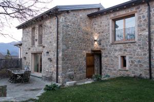 Cette maison en pierre dispose d'une terrasse et d'une table. dans l'établissement Corte della Maddalena, à Busana