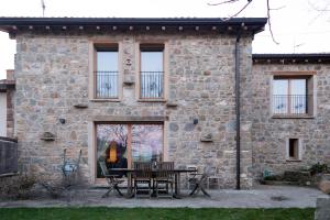 a stone house with a table and chairs in front of it at Corte della Maddalena in Busana