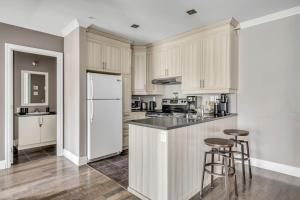 a kitchen with white cabinets and bar stools at INITIAL - CAVALIER - Chutes-Montmorency in Boischâtel +35 photos