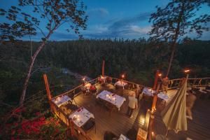 a group of people standing on a deck at night at Gaia Riverlodge in San Ignacio