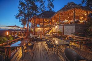 a restaurant with tables and chairs on a deck at night at Gaia Riverlodge in San Ignacio +106 photos