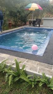 a pool with a pink ball and an umbrella at Lake Forest Holiday Resort in Kataragama