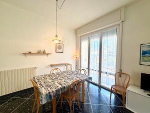 ein Esszimmer mit Tisch und Stühlen und einem Fenster in der Unterkunft Appartamento Roggero in Levanto