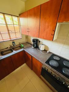a small kitchen with a stove and a sink at Sleep in Crestwave villas in eMalahleni +25 photos