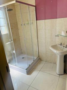 a bathroom with a shower and a sink at Sleep in Crestwave villas in eMalahleni