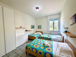 ein Schlafzimmer mit zwei Betten und einem Fenster in der Unterkunft Appartamento Roggero in Levanto