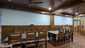 a conference room with a table and chairs and a large screen at Kunzang Homestay in Shalkār