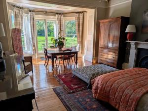 a bedroom with a bed and a table and a dining room at The Lawns House in Holt +21 photos