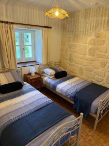 a bedroom with two beds and a stone wall at Reves au Soleil in Thiviers +47 photos