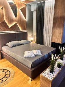 a bedroom with a bed with two towels on it at TULUM luxury suites-SKOPJE in Skopje +54 photos